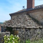 a picture of an old stone building with a stone roof