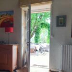 a picture looking through a door onto a terrace with greenery