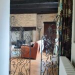 a picture looking though an entrance to a room with decorative metal gates